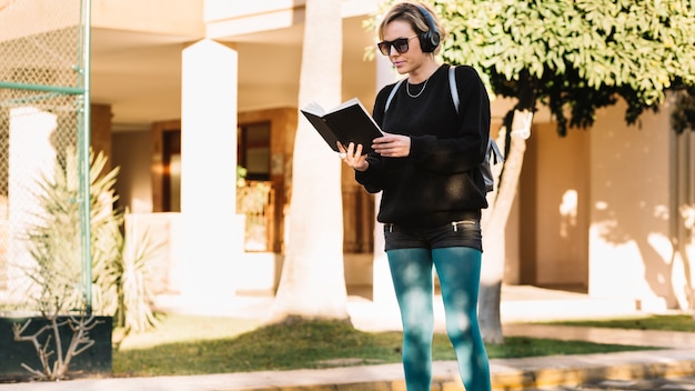 Woman reading book on street