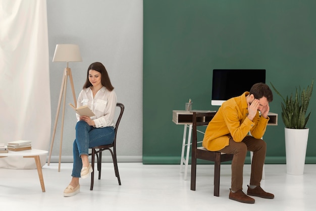 Woman reading a book while man is stressed