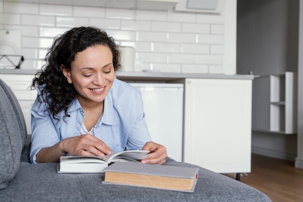 Woman reading on couch full shot