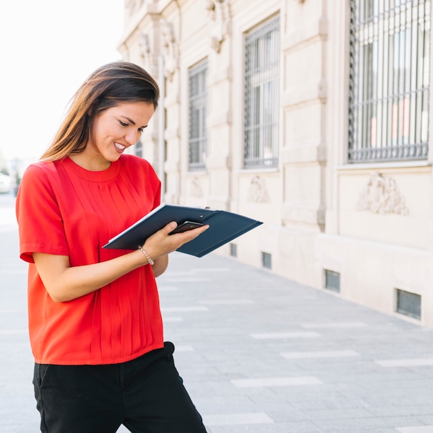 Woman reading diary in city