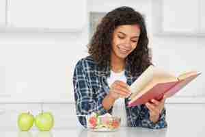 Free photo woman reading next to green apples