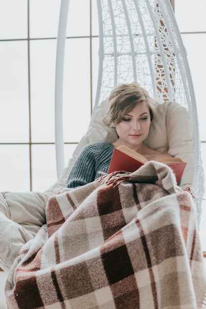 Woman reading on hanging chair