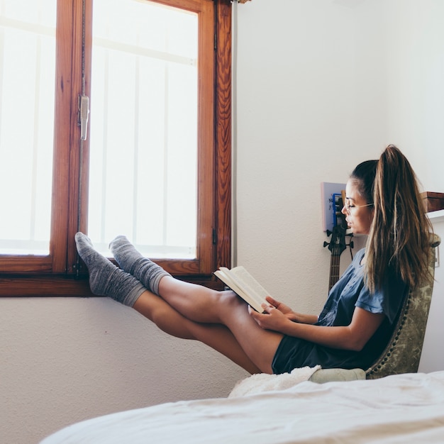 Free photo woman reading near window