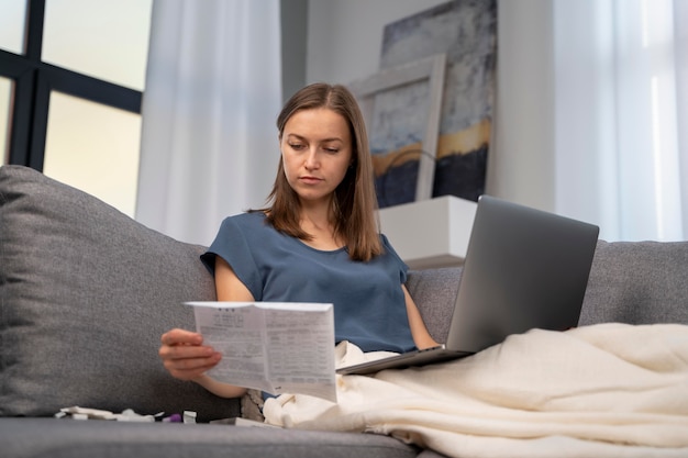 自宅でcovidテストの指示を読んでいる女性