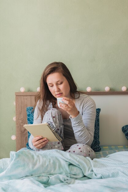 女性がベッドにいる間読書