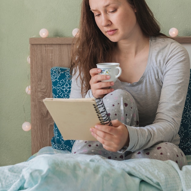 無料写真 女性がベッドにいる間読書