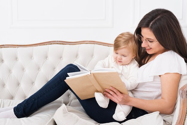 Woman reading with baby on sofa