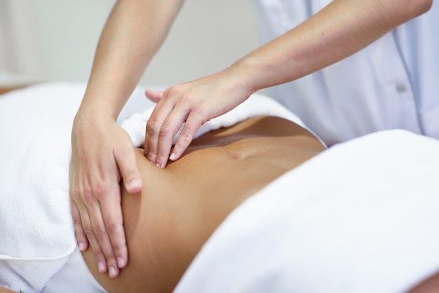 Woman receiving a belly massage at spa salon