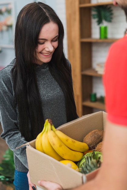 Free photo woman receiving fruits with courier