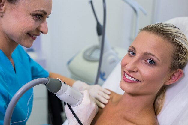 Woman receiving laser epilation treatment on her body