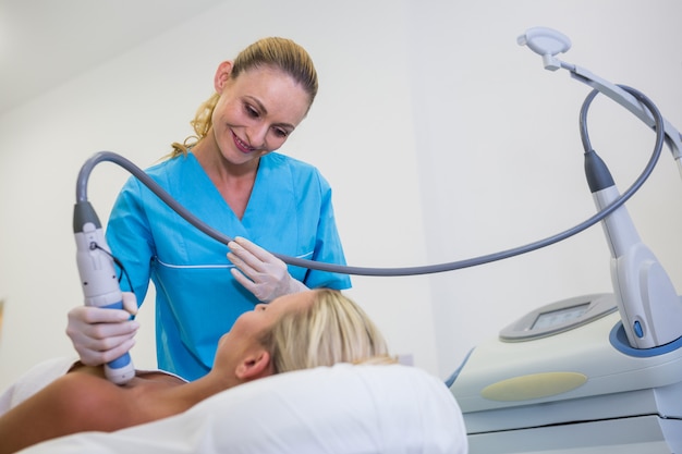 Woman receiving laser epilation treatment on her body