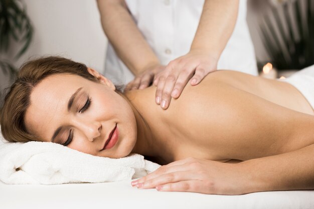 Woman receiving massage in spa center