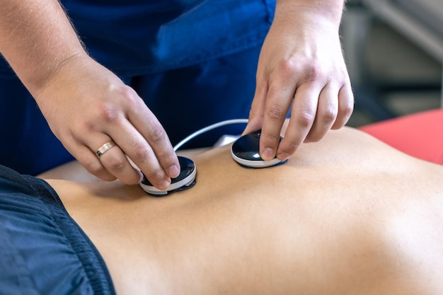 Foto gratuita donna che riceve un trattamento di miostimolazione in una clinica di terapia fisica