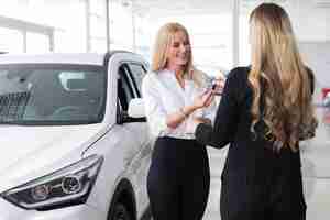 Foto gratuita donna che riceve la chiave della nuova auto