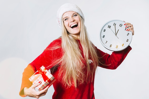 Woman in red clothes with clock and small gift box