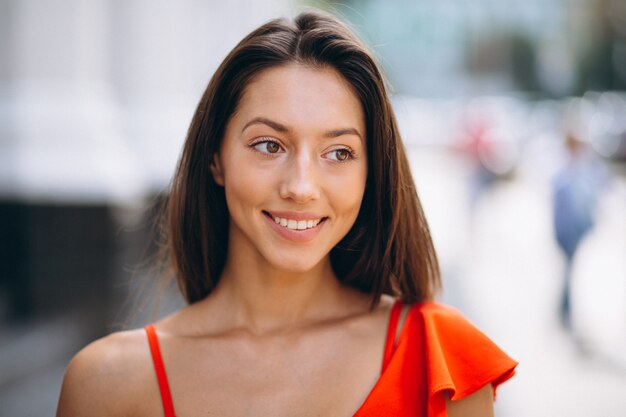 Woman in red dress model posing outside