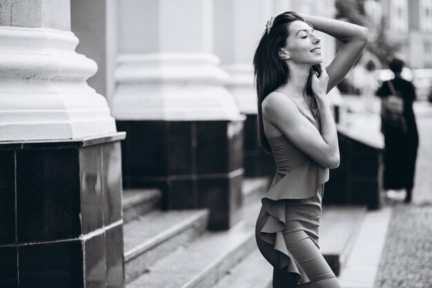 Woman in red dress model posing outside