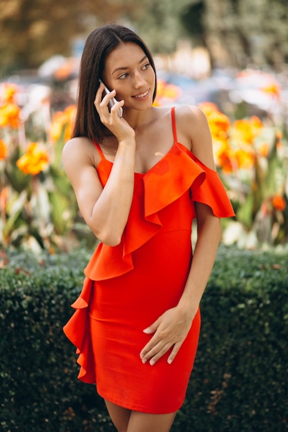 Женщина в красном платье с телефоном