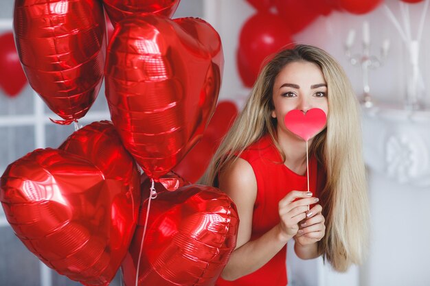 woman in red dress with heart in hands