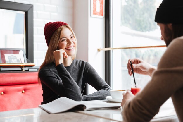 Woman in red hat talking with man