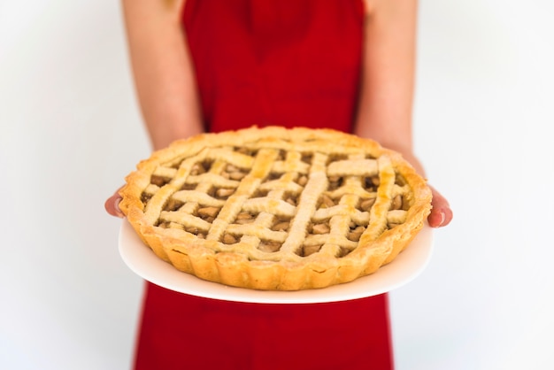 Woman in red holding plate with apple pie