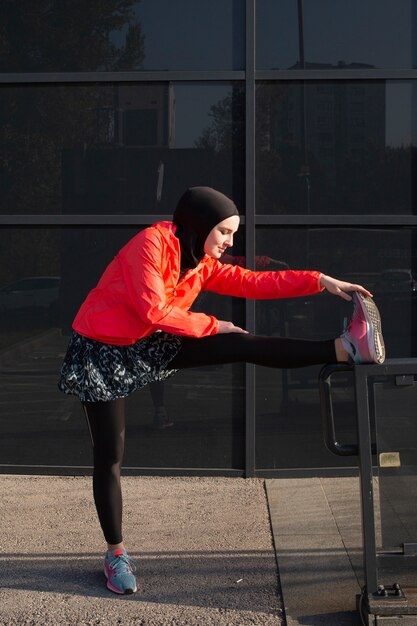 Woman in red jacket stretching