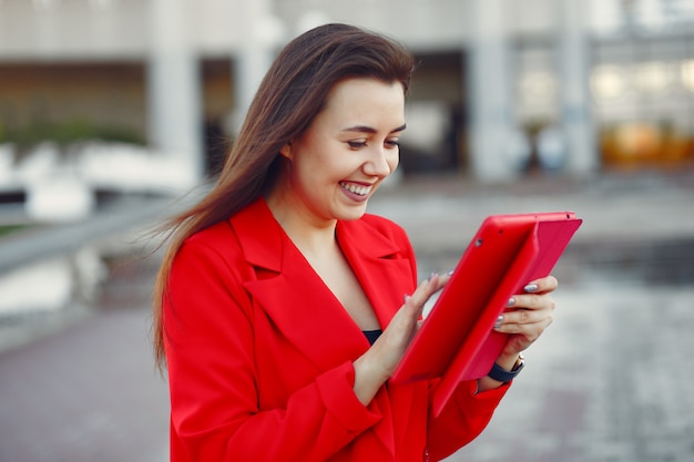 タブレットを使用して赤いジャケットの女性