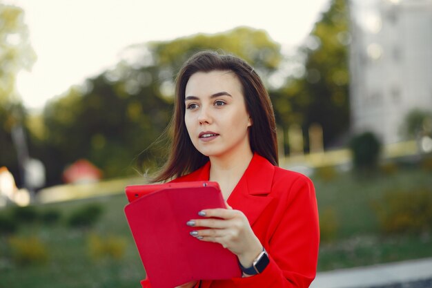 Woman in red jacket using a tablet