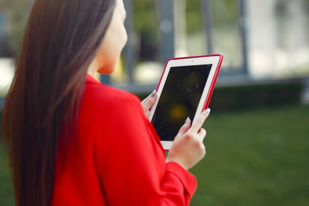 タブレットを使用して赤いジャケットの女性