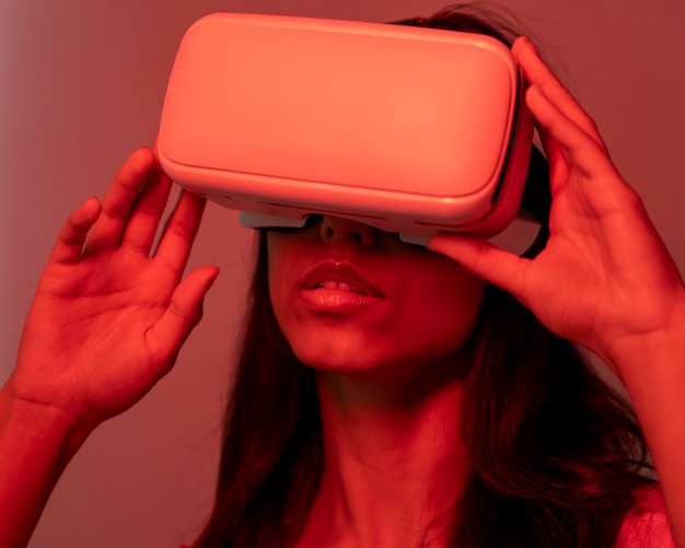 Woman in red light using virtual reality headset