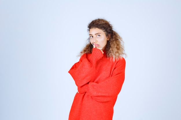 woman in a red shirt looks pessimist or sad.