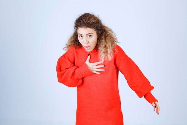 Free photo woman in a red shirt looks terrified and scared.