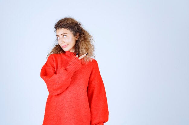 woman in red shirt pointing someone on the right. 