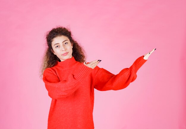 woman in red shirt pointing at something on the right.