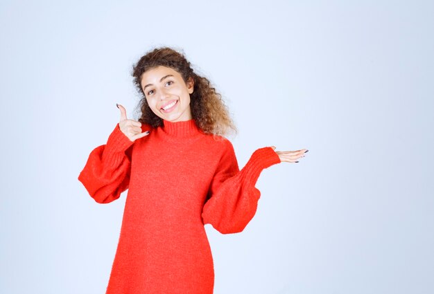 woman in red shirt showing call sign. 