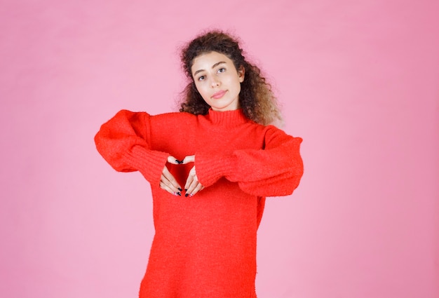 Free photo woman in red shirt showing heart sign.