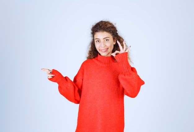 Donna in camicia rossa che mostra come il segno della mano.