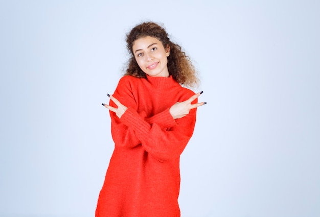 woman in red shirt showing peace and friendship sign. 