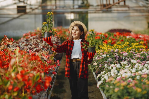 빨간 셔츠에있는 여자. Flowerpoots와 노동자입니다. 식물을 가진 딸