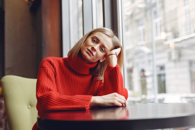 Woman in a red sweater. Lady in a restaurant.