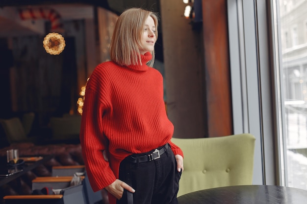 Woman in a red sweater. Lady in a restaurant.