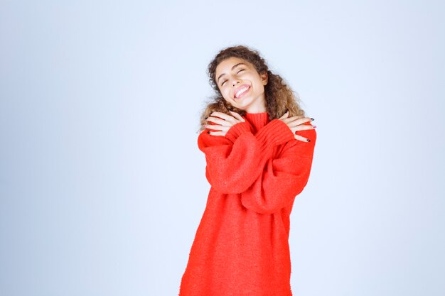 woman in red sweatshirt giving smiling and seductive poses. 