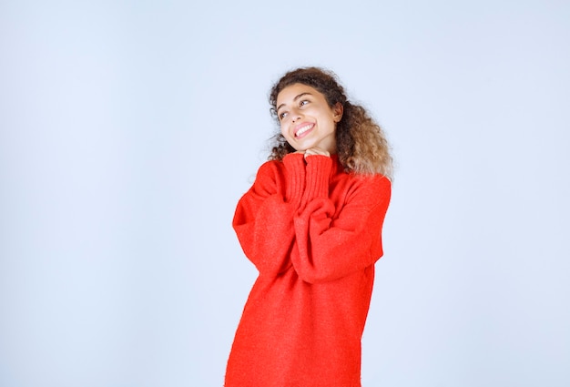 woman in red sweatshirt giving smiling and seductive poses.