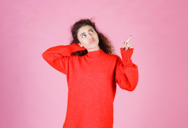 woman in red sweatshirt looks confused and lost. 