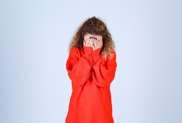 Free photo woman in red sweatshirt looks exhausted and sleepy.