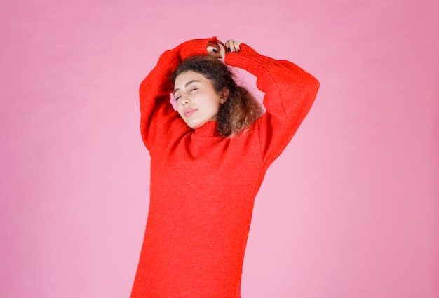 woman in red sweatshirt looks exhausted and sleepy.