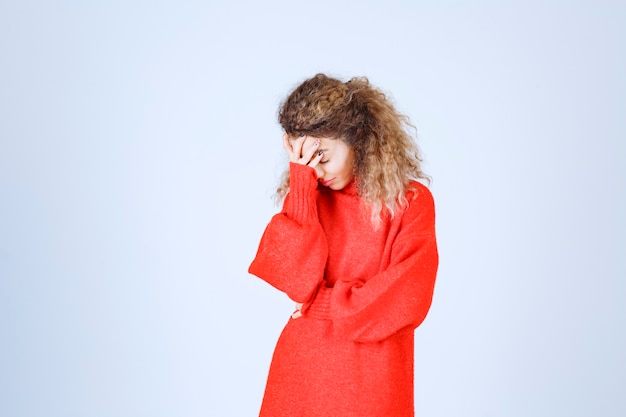 woman in red sweatshirt looks sleepy. 