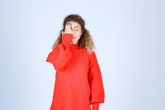 woman in red sweatshirt looks sleepy. 