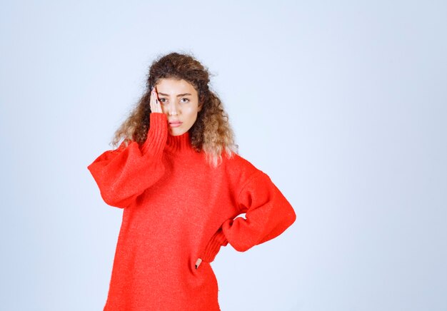 woman in red sweatshirt looks terrified and scared. 