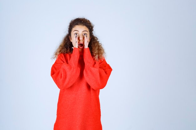 woman in red sweatshirt looks tired and sleepy.